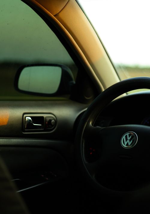 Free Detail shot of Volkswagen car interior focusing on steering wheel and door. Stock Photo