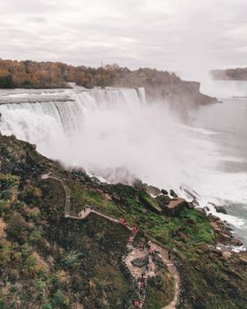 A scenic aerial view of Niagara Falls with lush autumn foliage, showcasing the majestic waterfall.
