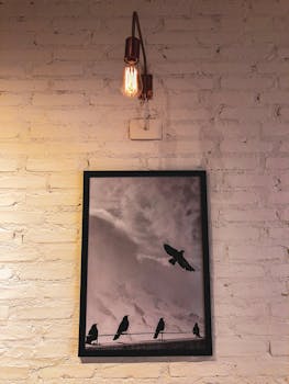 复古艺术中，鸟类剪影在砖墙上的爱迪生灯泡下展现