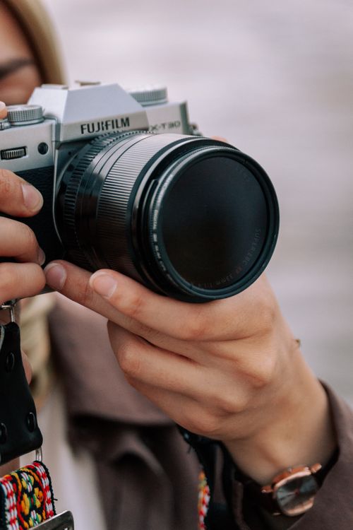 Free Close-up of a person holding a camera, showcasing hands and photography equipment. Stock Photo