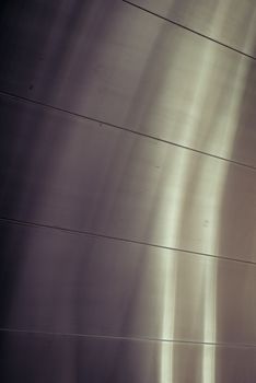 Close-up of a metallic surface with soft light reflections, showcasing smooth lines and textures.