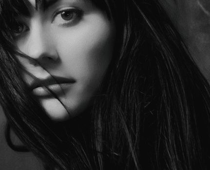 Elegant black and white close-up portrait capturing a woman's expressive gaze.
