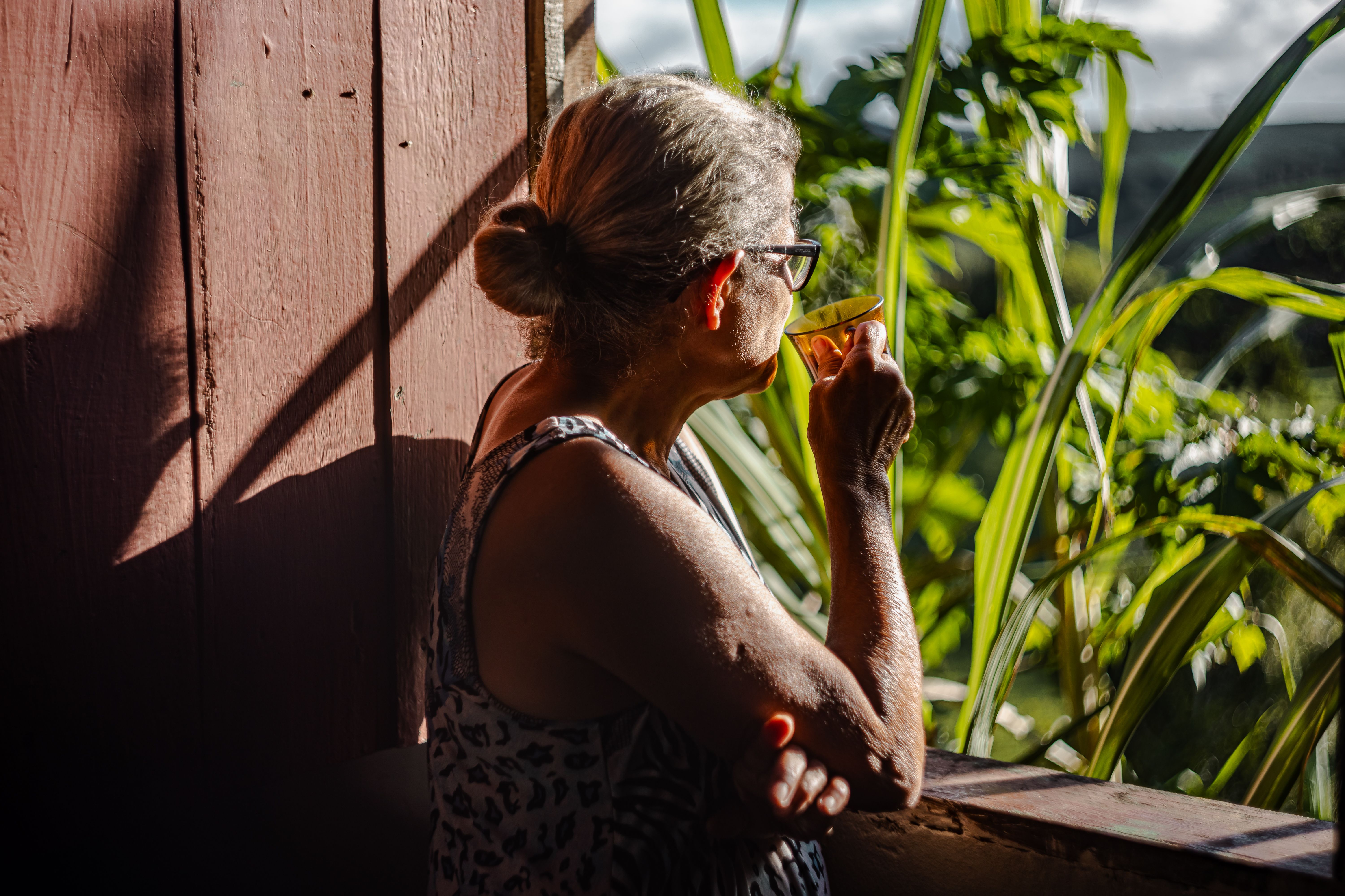 woman relaxing on balcony with coffee morning sunlight peaceful