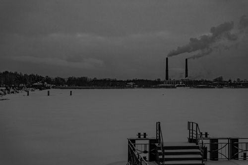 Free A captivating black and white image of an urban industrial landscape during winter with a snowy foreground. Stock Photo