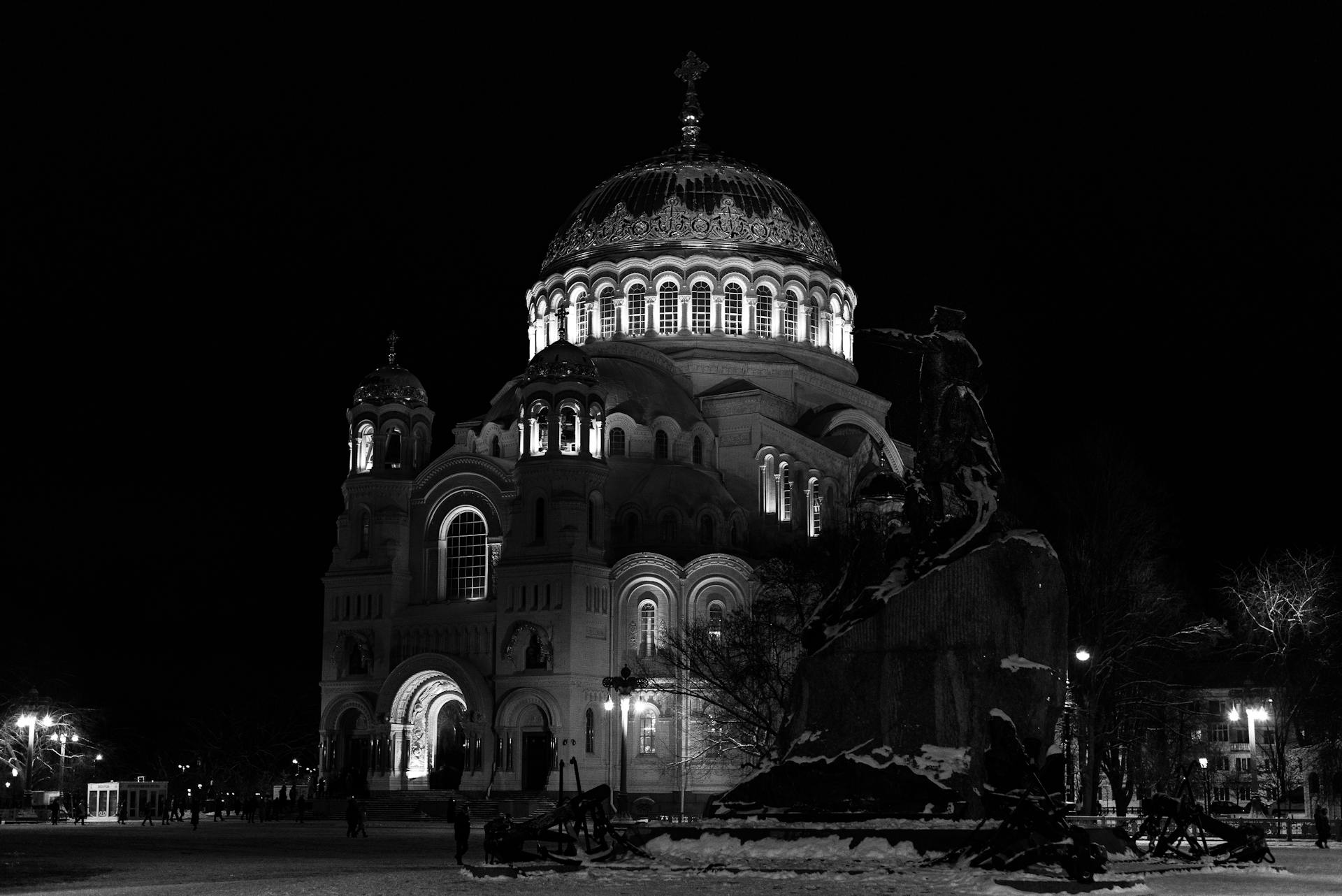 Black and white photo of the illuminated Navy Cathedral in Kronstadt, Russia at night.