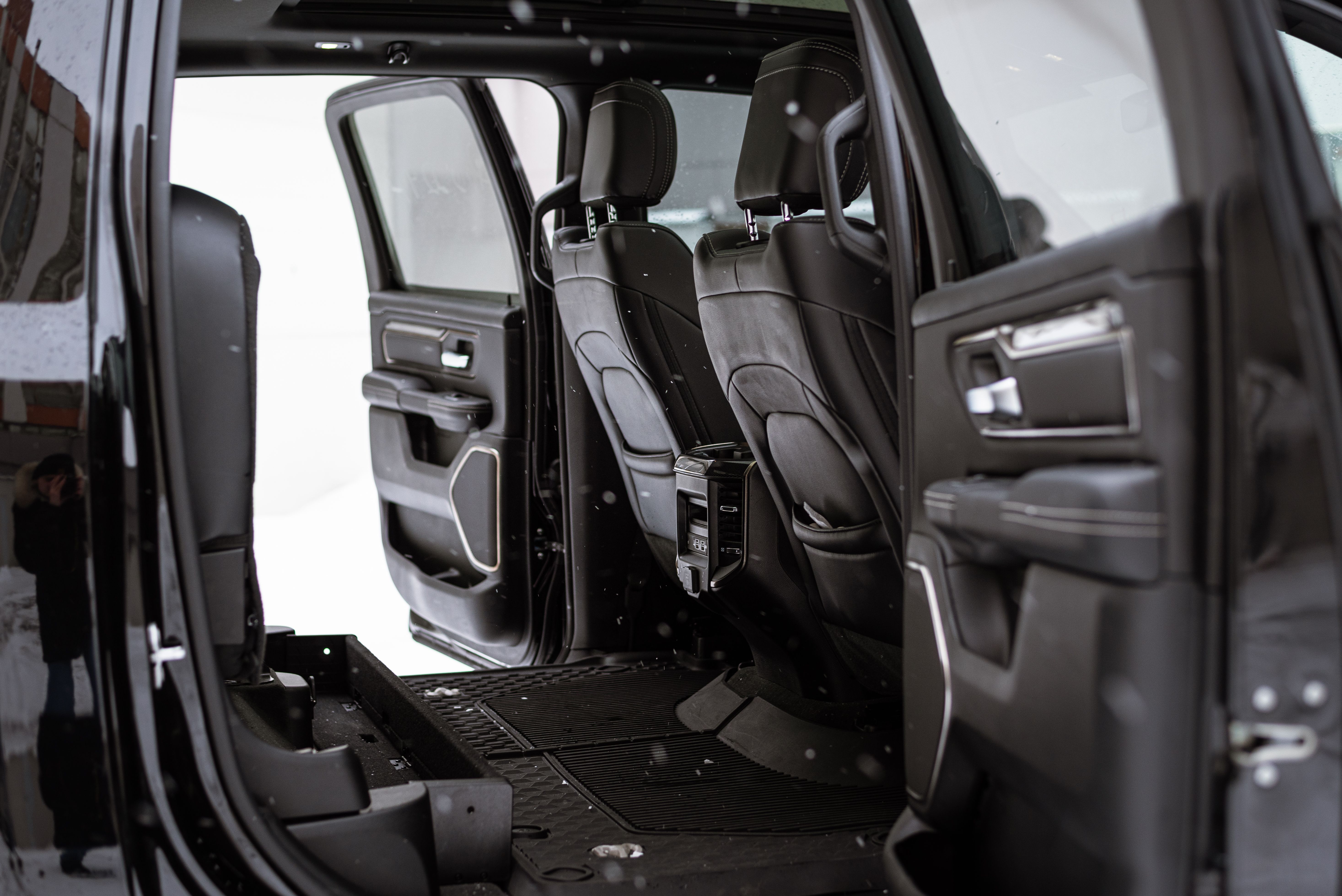 Explore the luxurious black seating of a modern vehicle interior with open doors.