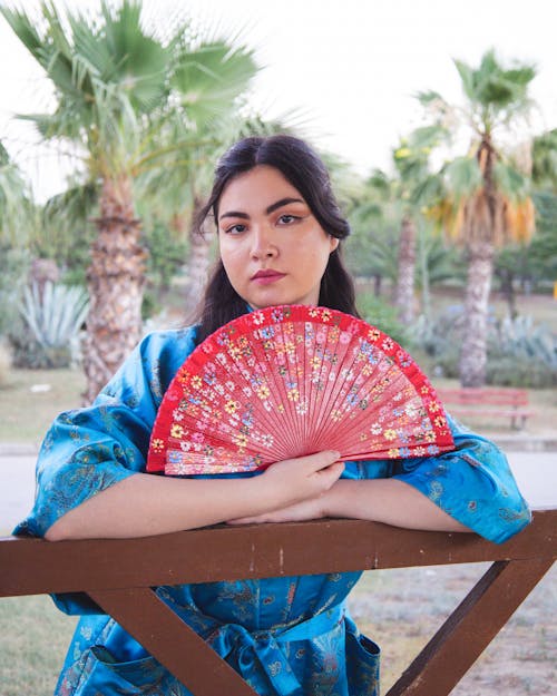 Model in a Blue Kimono Holding a Floral Red Fan