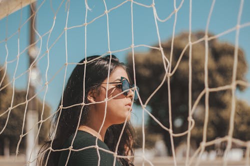 Frau, Die Schwarze Sonnenbrille Trägt, Die Neben Sportnetz Steht