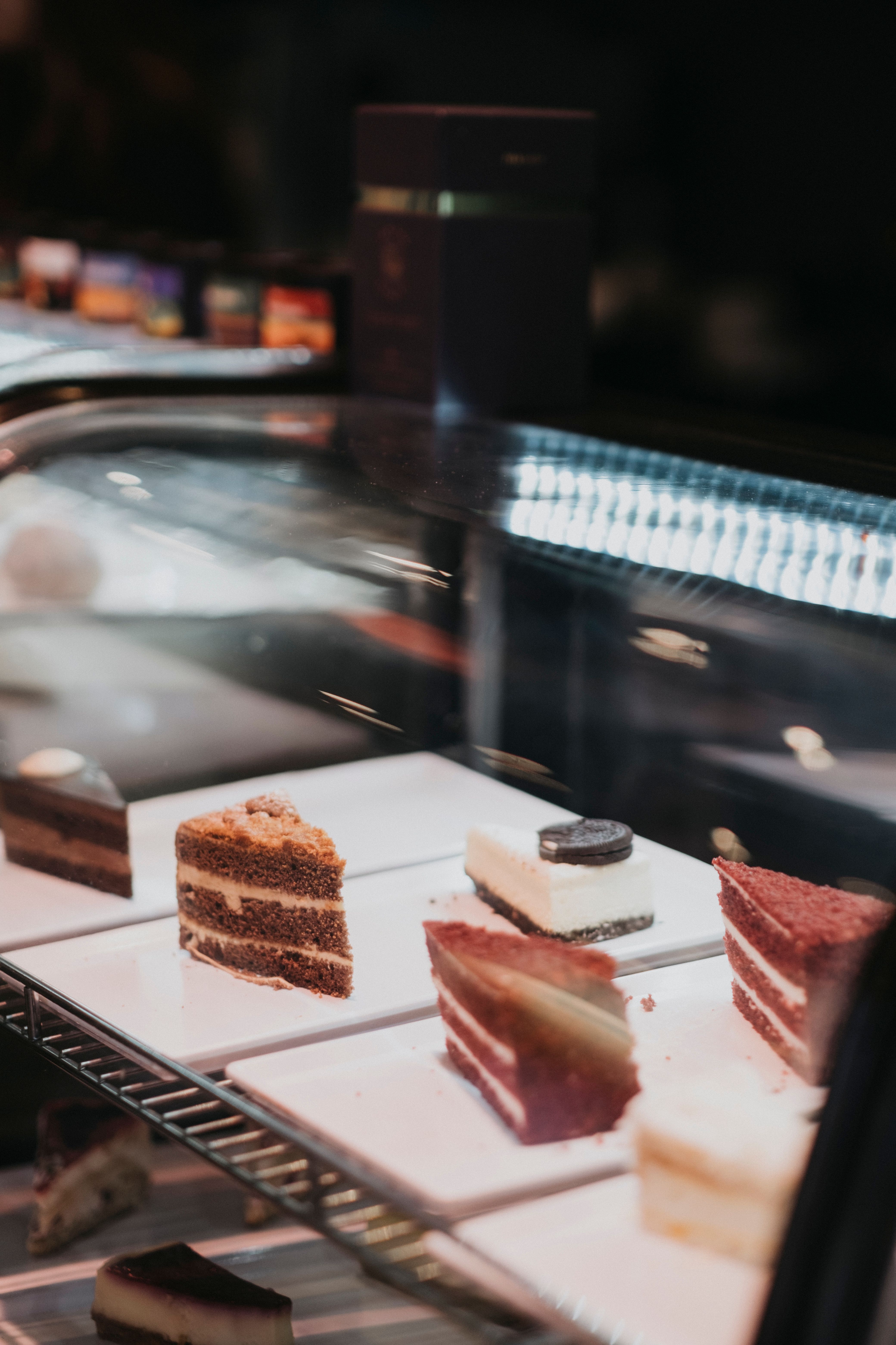 Selection of different cake slices displayed in a bakery showcase.