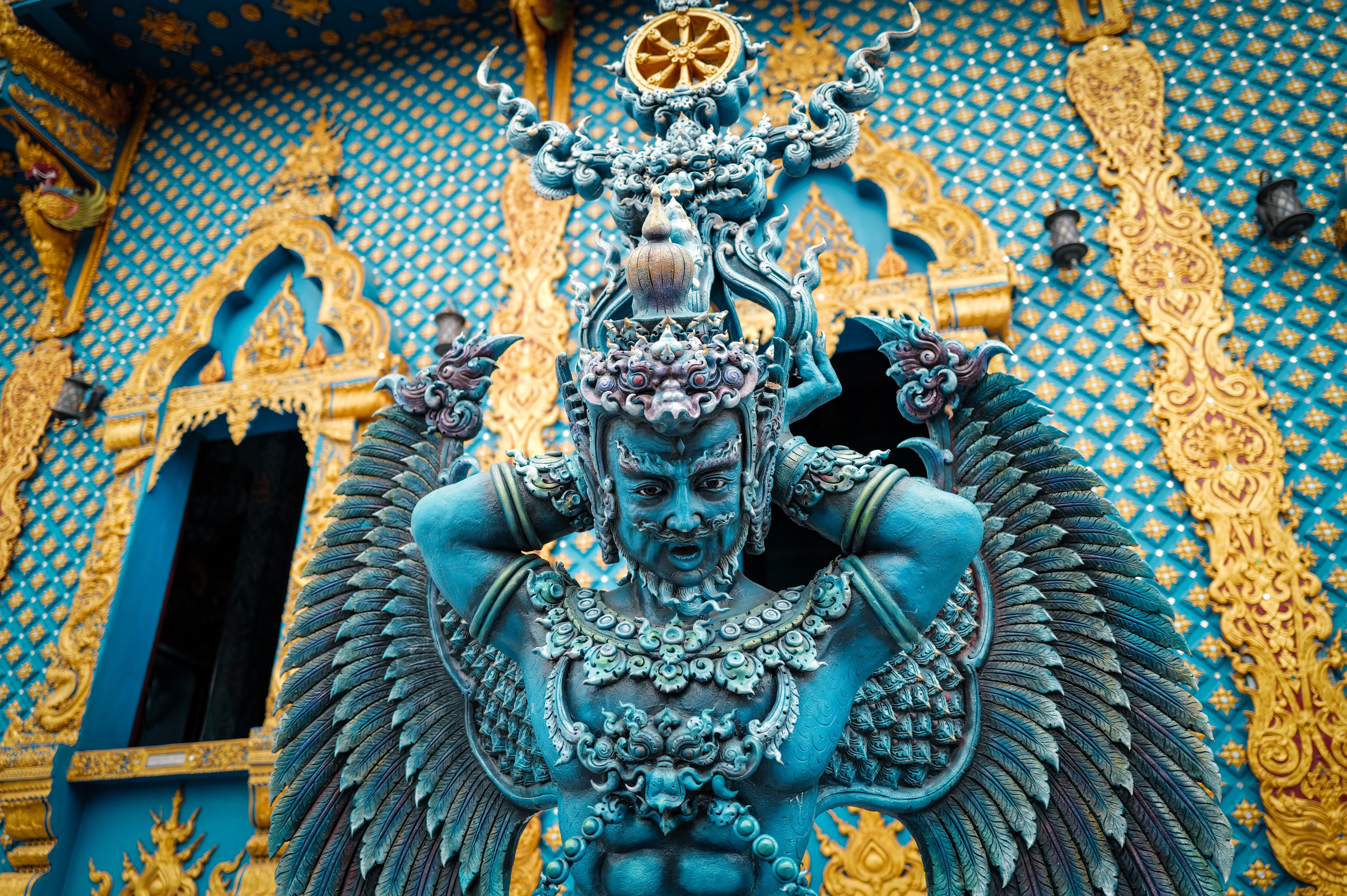 Exquisite blue religious sculpture with gold detailing at a Thai temple.