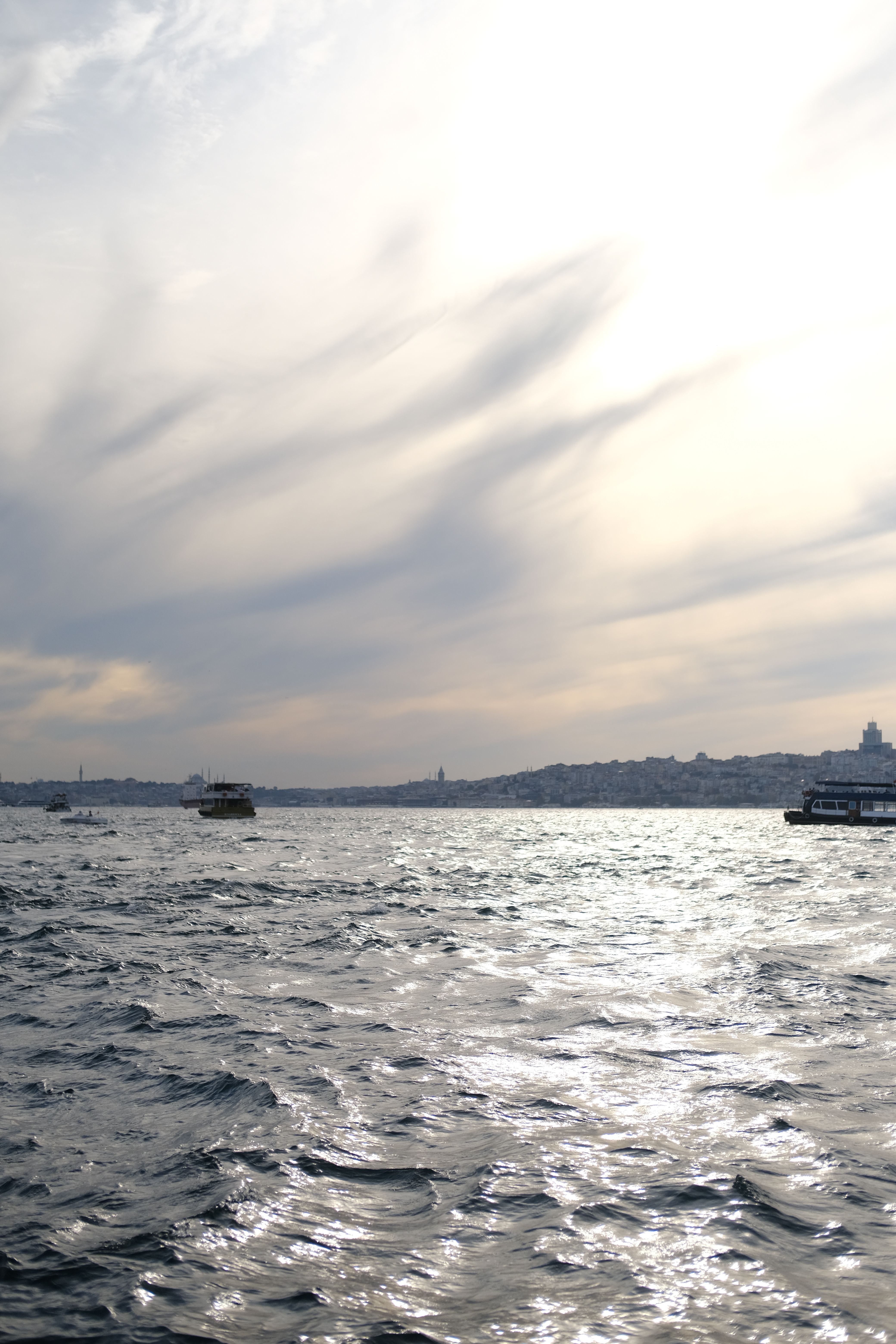 A boat is sailing on the water with a cloudy sky · Free Stock Photo