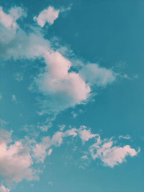 Free A tranquil view of a clear blue sky dotted with soft, fluffy clouds. Perfect for nature backgrounds. Stock Photo