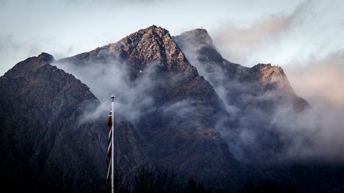 Free Dramatic misty mountain scene with a Norwegian flag in the foreground. Stock Photo