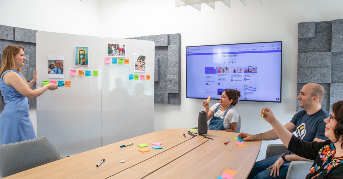 team members collaborating on a shared digital whiteboard with sticky notes and flowcharts