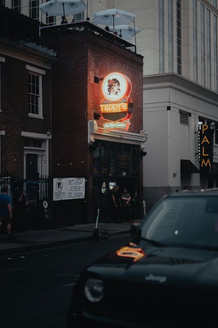 Urban street view in Nashville, TN with vibrant neon signs and classic architecture.