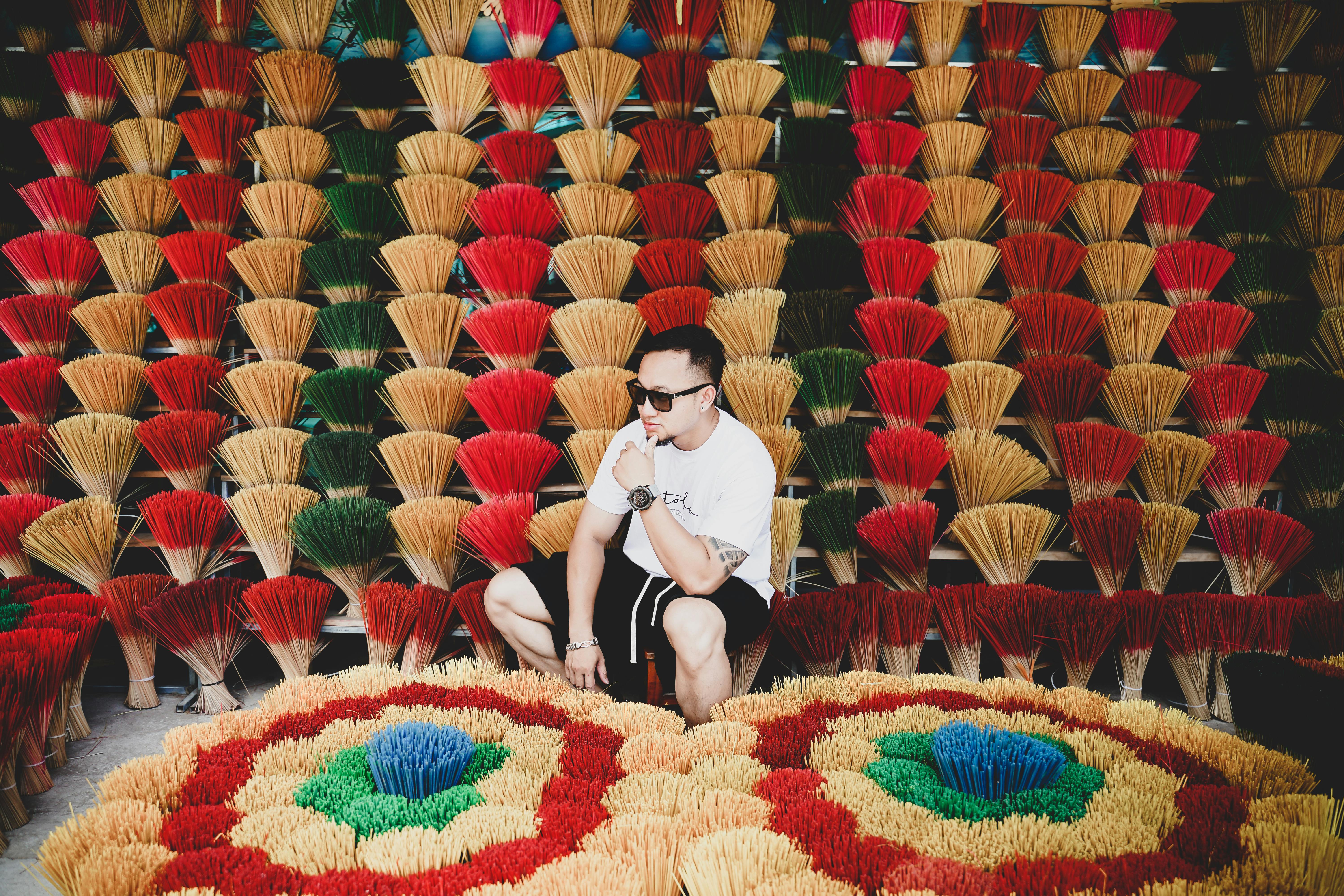 a man sitting on a chair surrounded by colorful straws