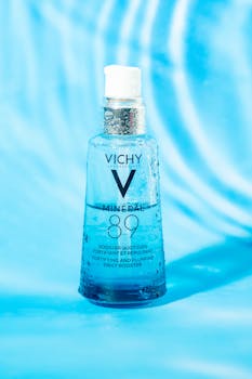Vichy Mineral 89 serum bottle on textured blue backdrop for skincare aesthetics.