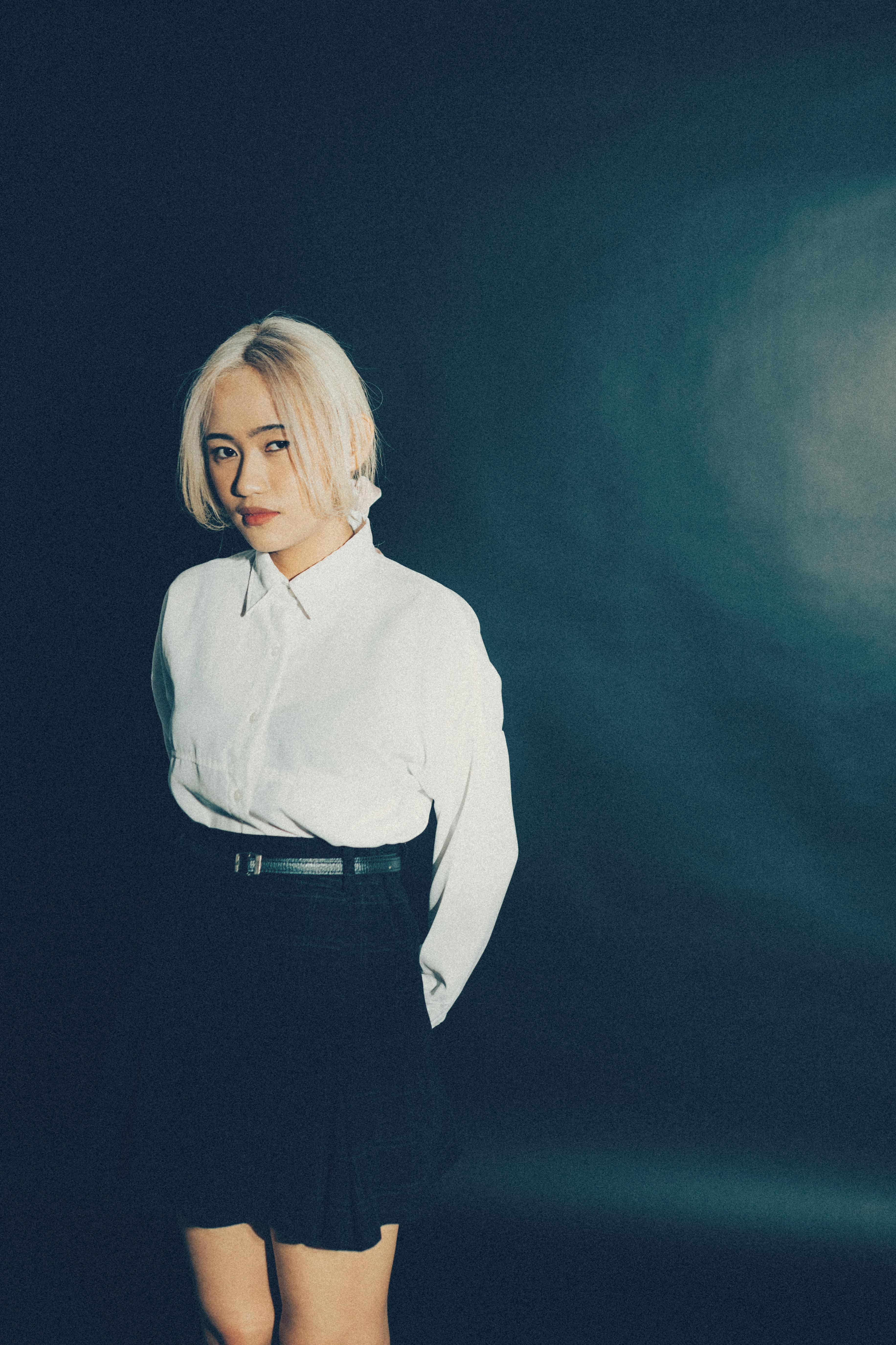 Stylish woman posing confidently in a studio portrait with dramatic lighting.