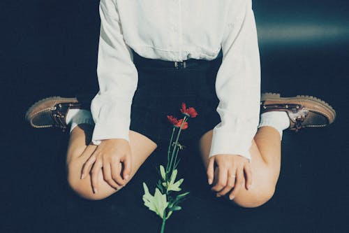 A girl sitting on the floor with a flower