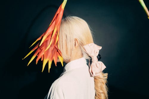 A woman with long blonde hair and a flower on her head