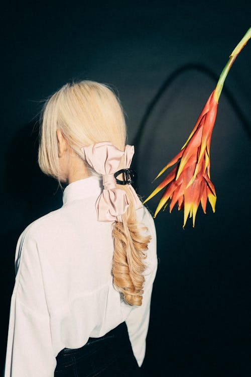 A woman with blonde hair and a flower in her hair