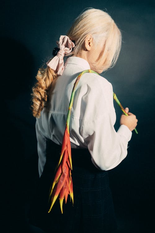 A woman with long hair holding a flower