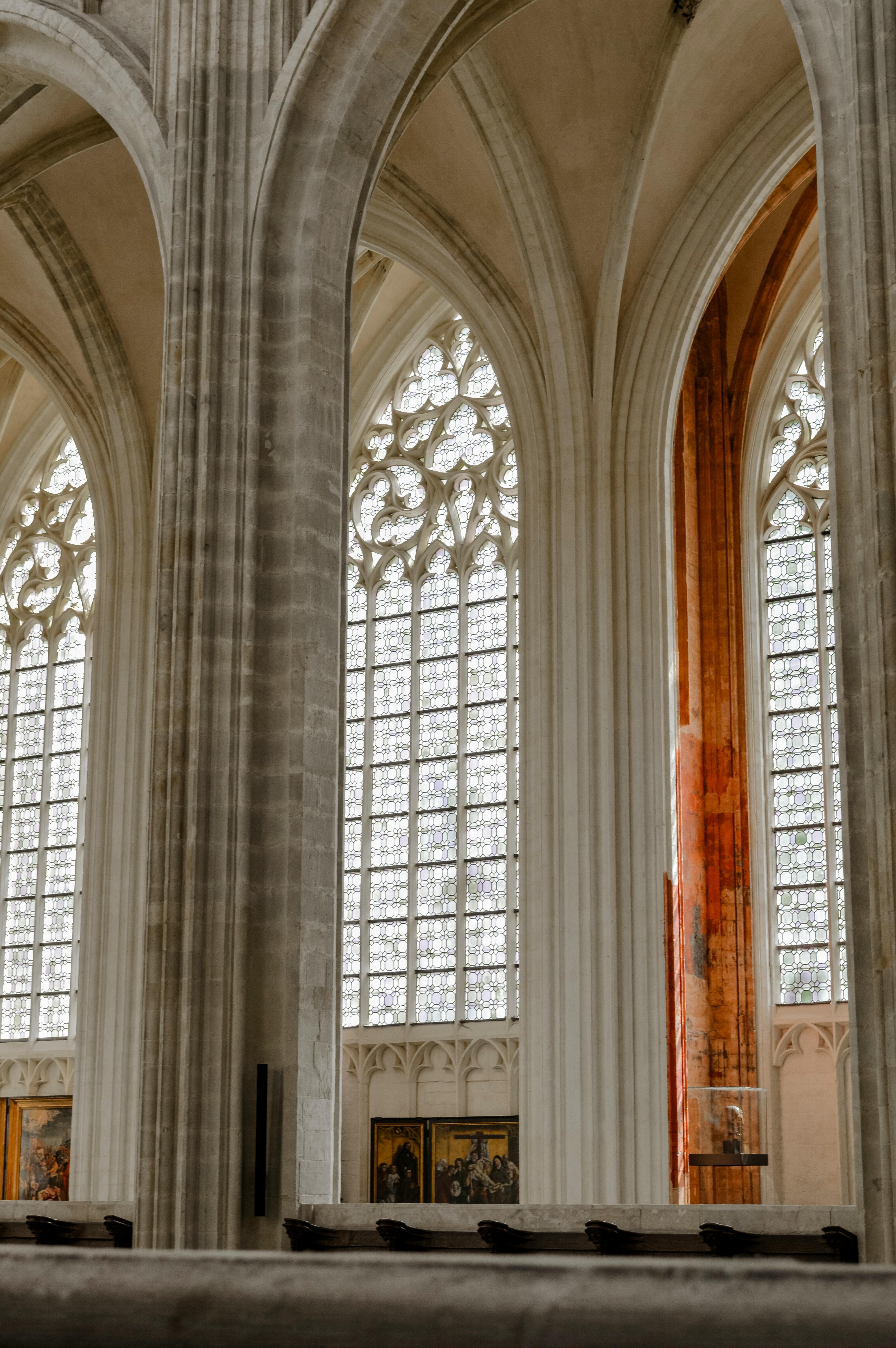 Ornate gothic interior of a cathedral in Leuven, Belgium, featuring tall columns and detailed windows.