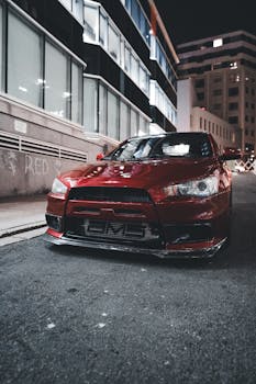 Red sports car parked on a nighttime city street, embodying speed and style.