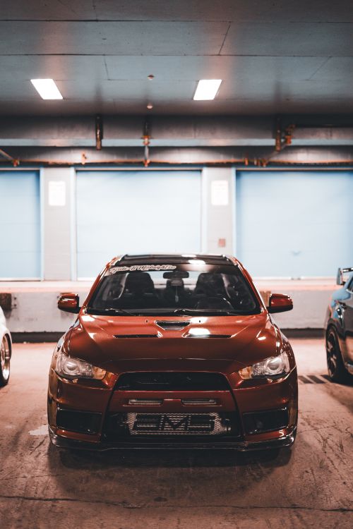 Free Front view of a red sports car parked indoors in a garage setting. Stock Photo