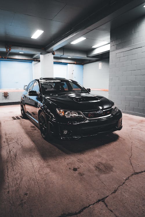 A black car parked in a garage · Free Stock Photo