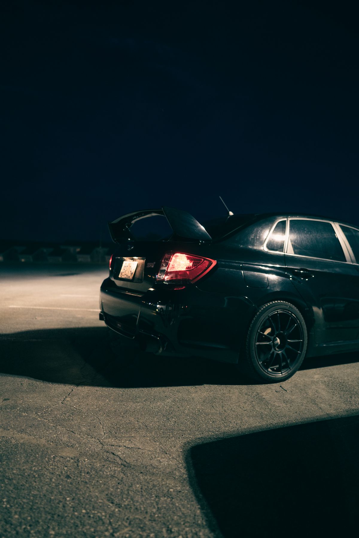 A black car driving down the road at night · Free Stock Photo