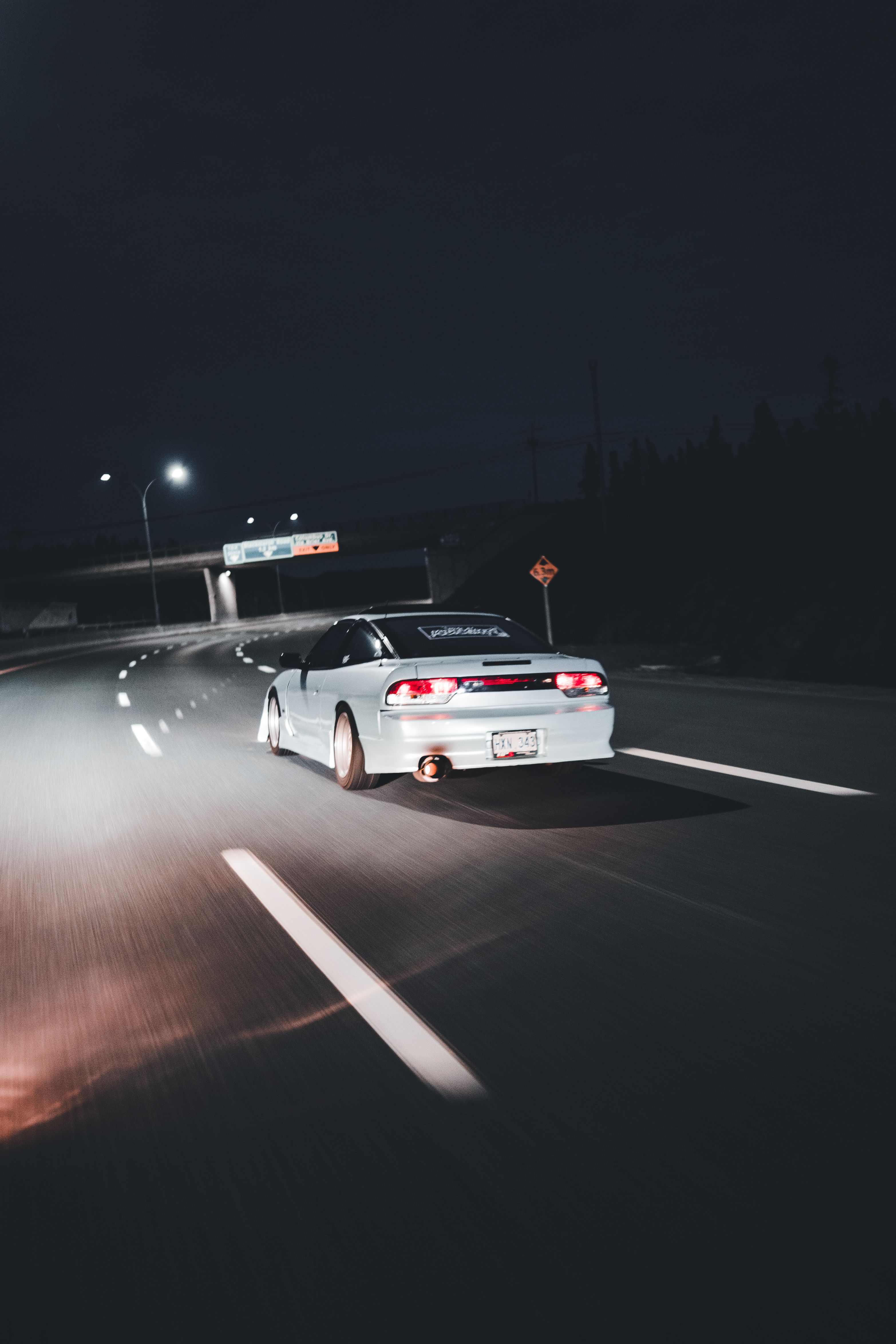 A car driving down the road at night · Free Stock Photo