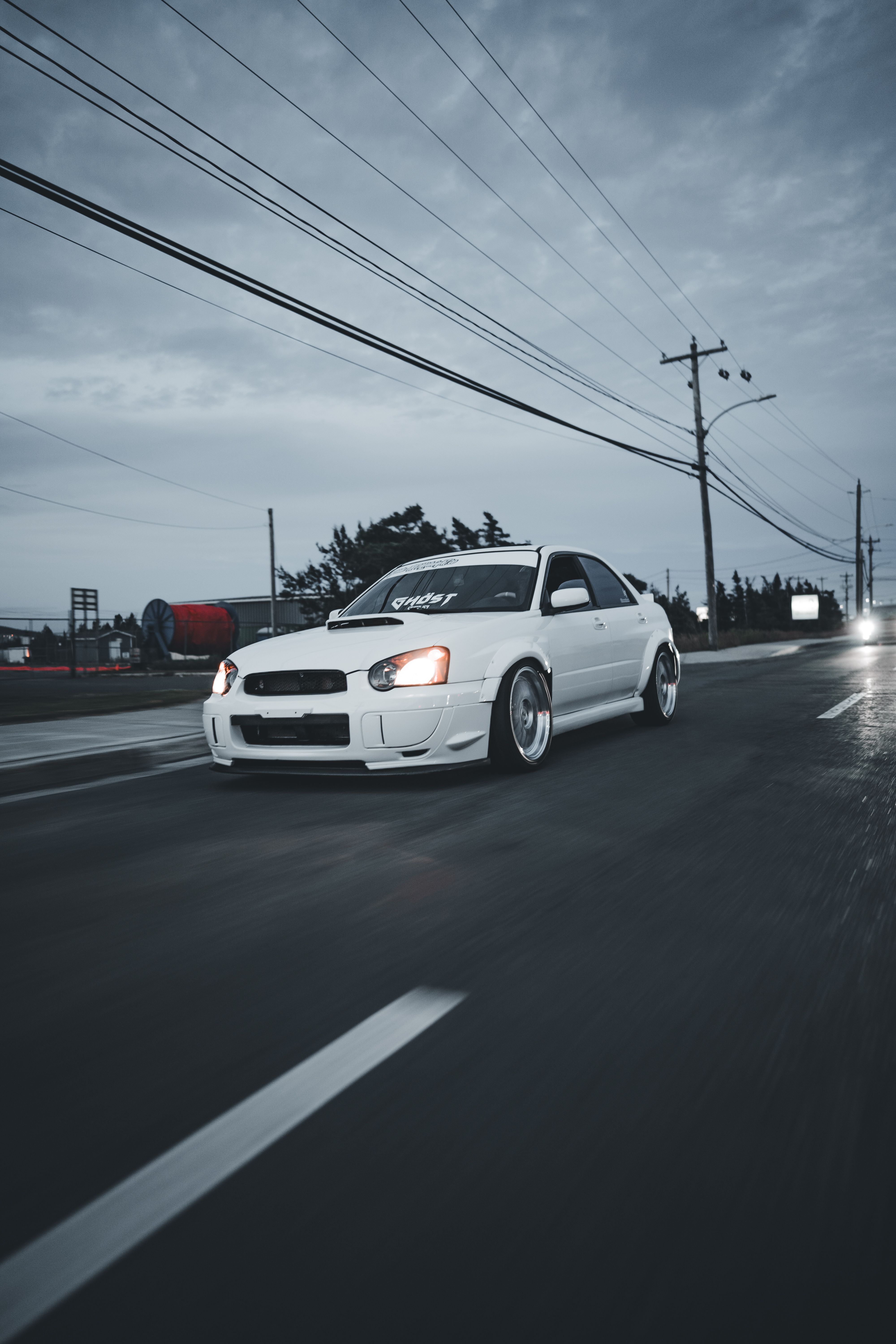 A white car driving down the road at night · Free Stock Photo