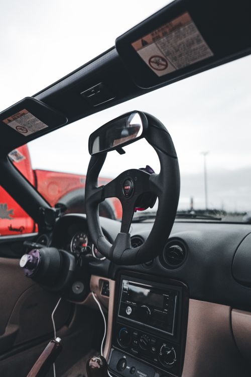 Free Close-up of a car's interior focusing on the steering wheel and dashboard details. Stock Photo