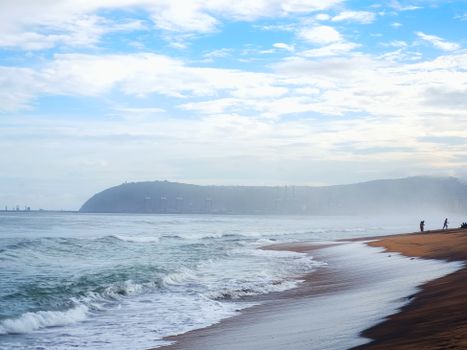 A tranquil beachline at dawn with soft waves and distant skyline, perfect for travel and nature themes.