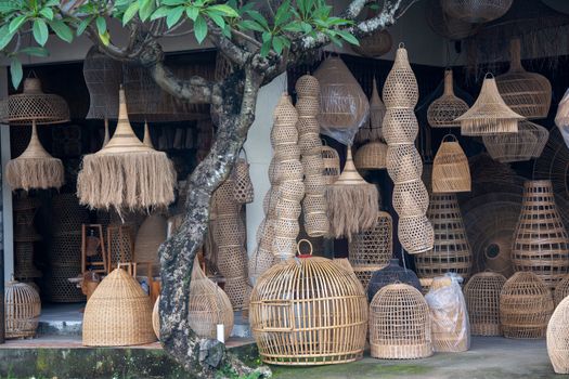 Explore beautifully crafted traditional bamboo lamps in an Indonesian market setting. Ideal for decor inspiration.