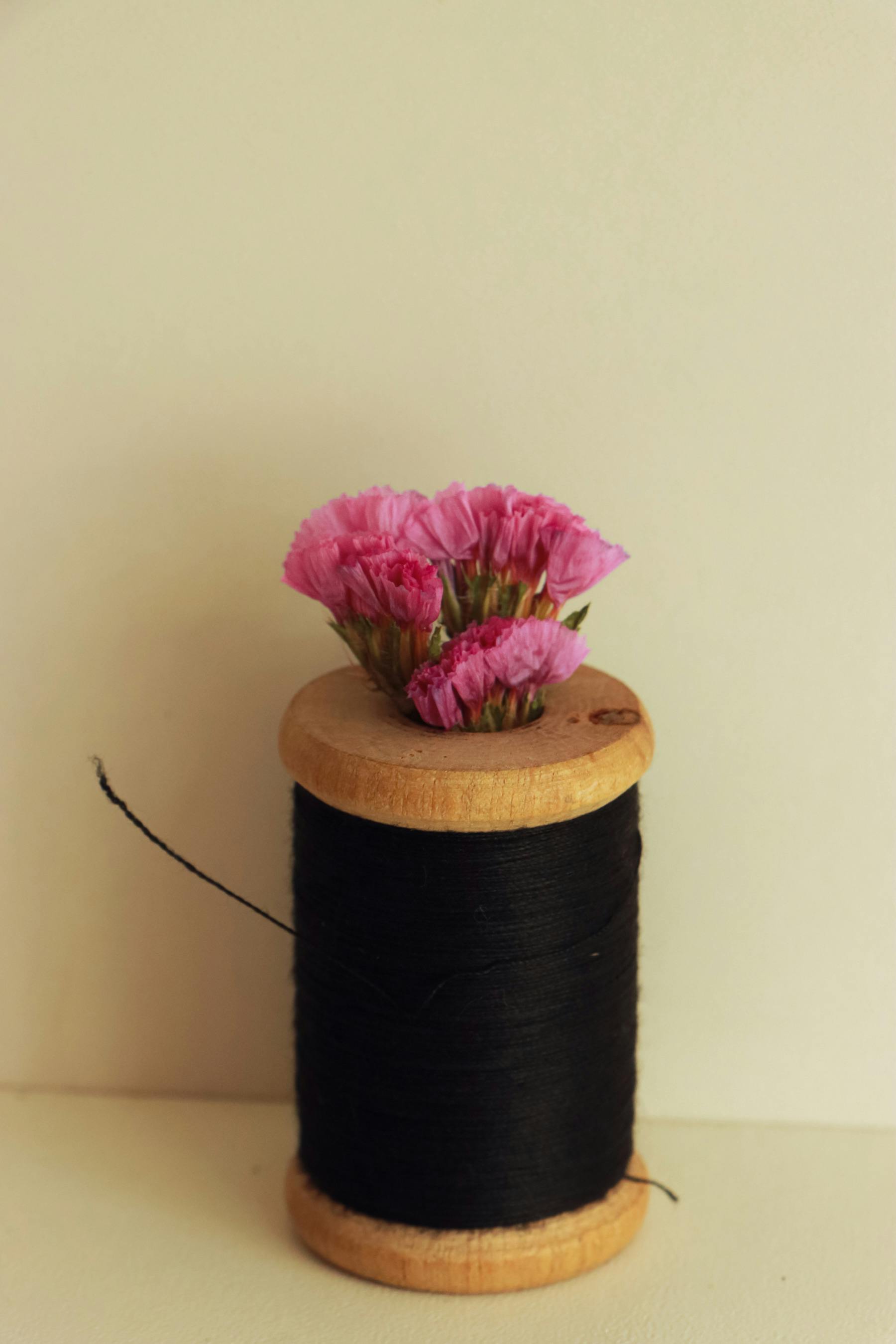 a spool of thread with pink flowers on it