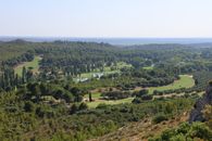 Breathtaking landscape of Mouriès, Provence, featuring lush greenery and rolling hills under a clear summer sky.