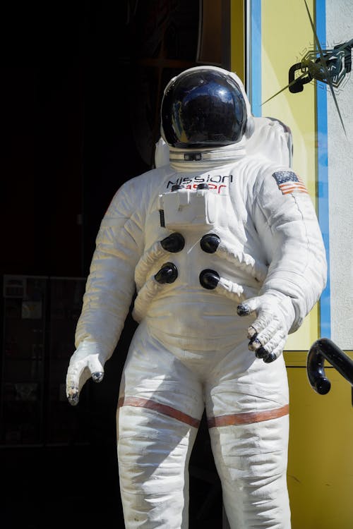 An astronaut suit is displayed in front of a building