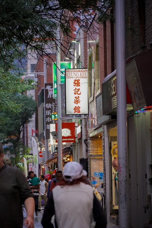 A woman walking down a street with a sign that says chinese