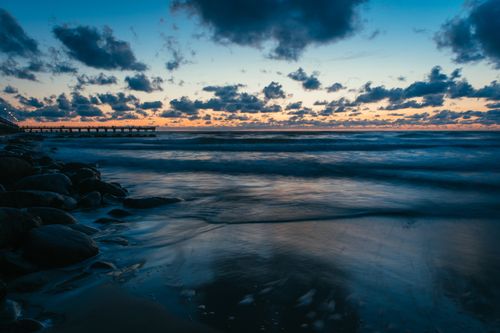 Free A stunning dusk view of the Baltic Sea at Palanga with clouds, waves, and a pier. Stock Photo