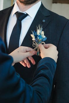 Close-up of a groom wearing a suit and boutonniere, ready for a wedding ceremony.