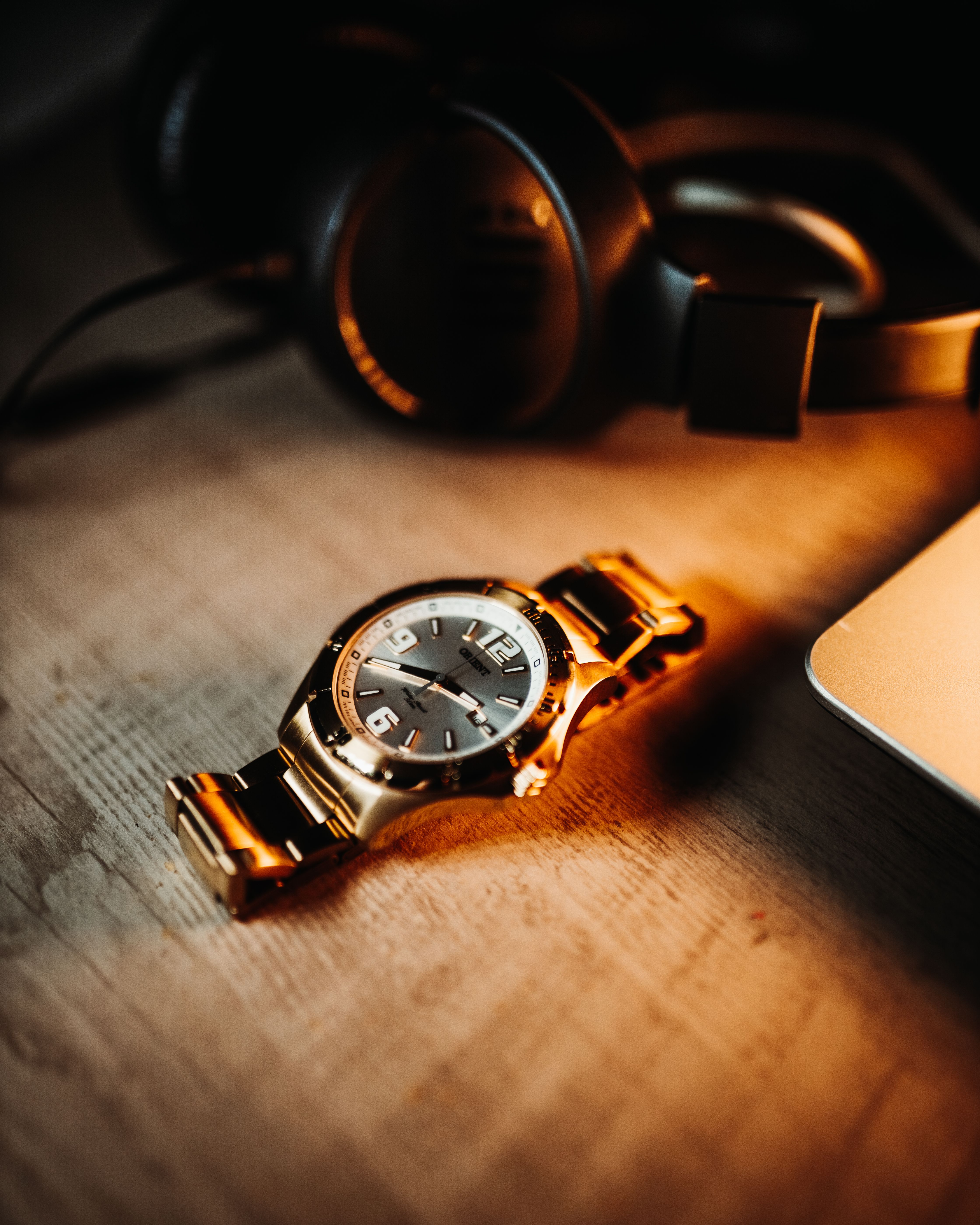 A gold watch sits on top of a laptop · Free Stock Photo