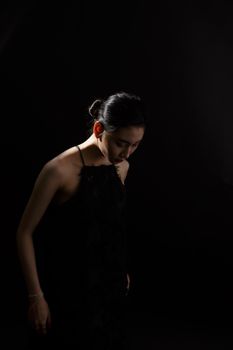 A stylish portrait of a woman in a studio with dramatic lighting and shadows.