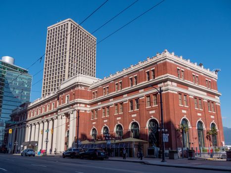 Captivating view of a historic red brick building in a vibrant urban cityscape under clear blue skies.