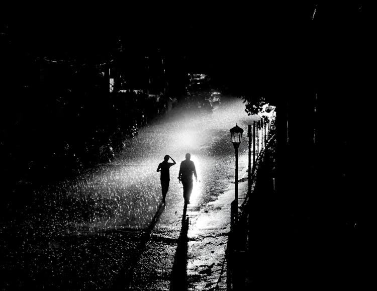 People Walking On Street In Rain At Night