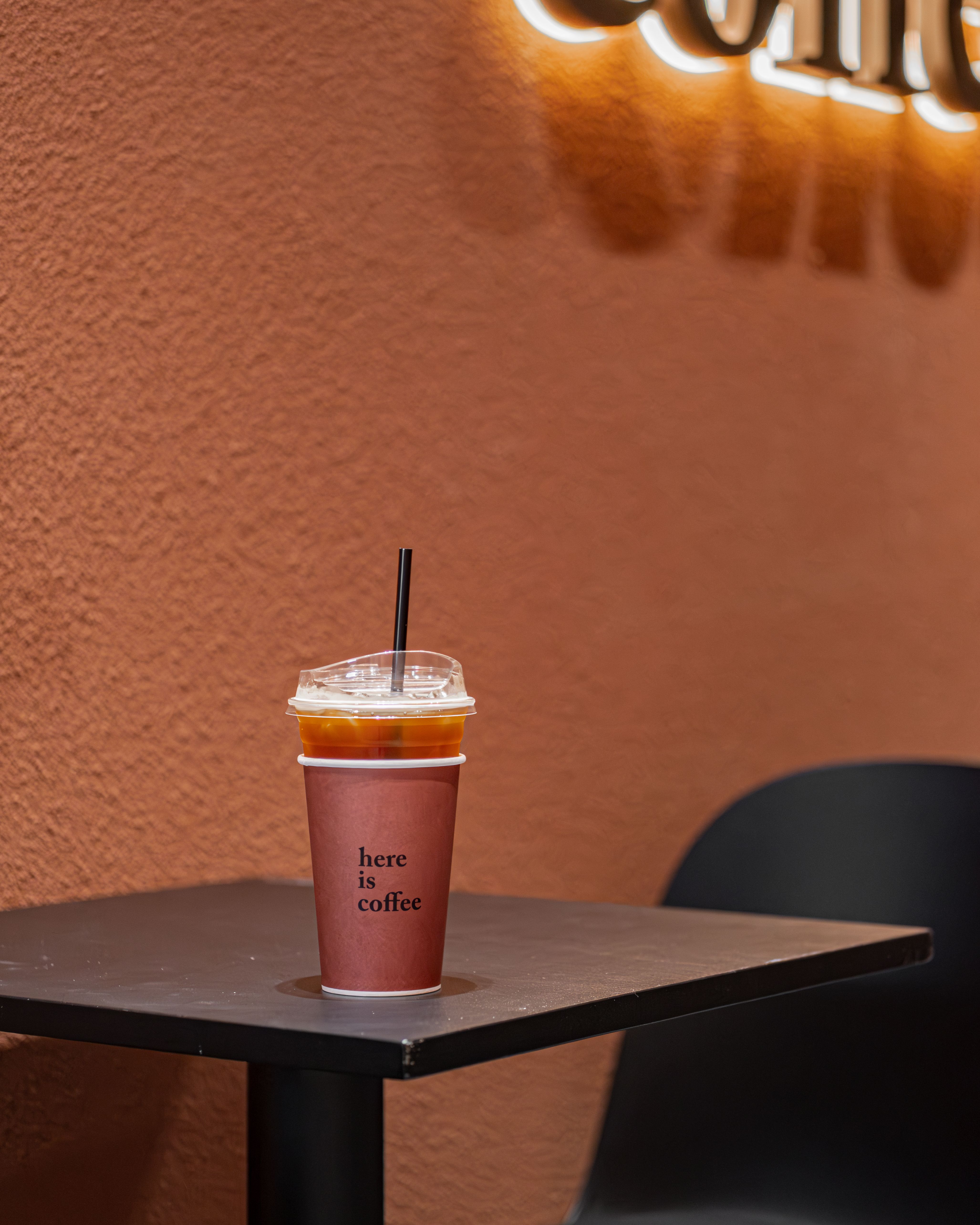 A fashionable iced coffee cup sitting on a modern table in trendy cafe setting.