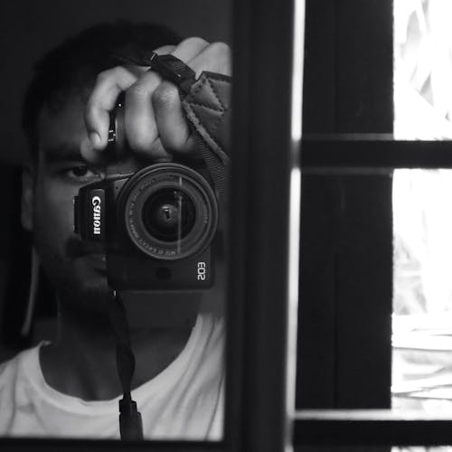 Free Man with Canon Camera Taking Selfie in Mirror Stock Photo