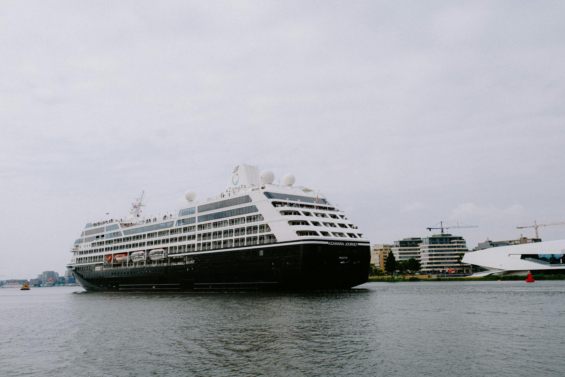 A large cruise ship is docked in a harbor