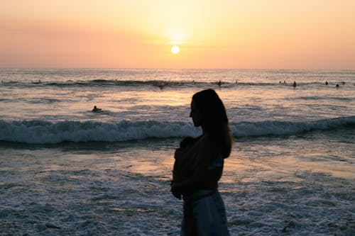 Woman with Baby on Beach at Sunset